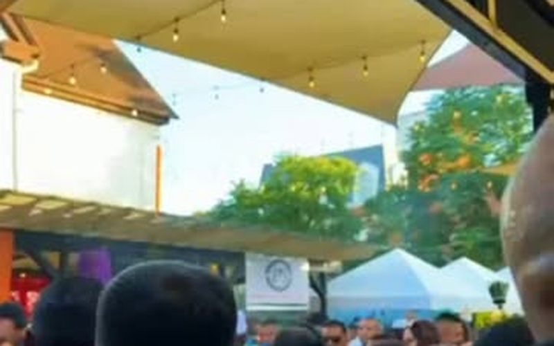 Outdoor company function with tents and a full crowd