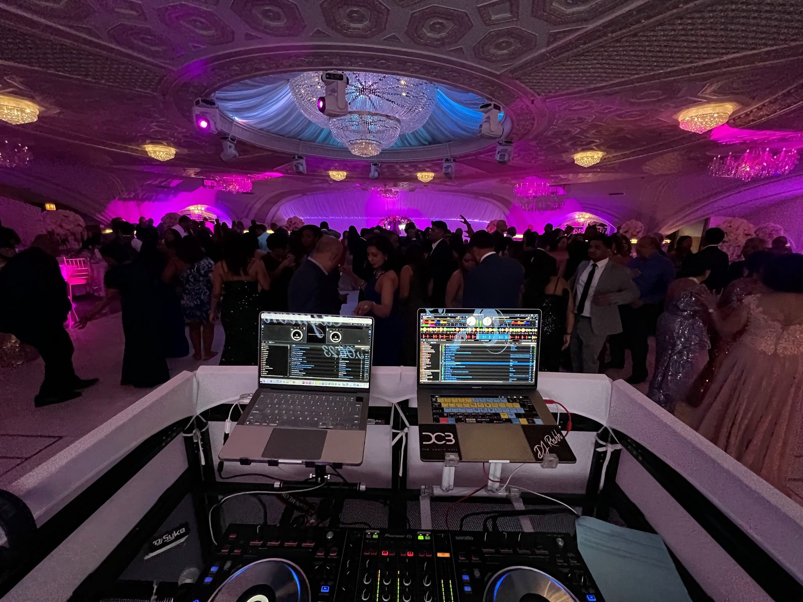 Booth view of a full ballroom under purple light